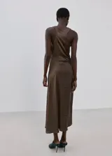 Vestido midi de satén color marrón, sin mangas y con cuello redondo. Presenta un diseño con frunces laterales en la cintura que crean un efecto drapeado y una silueta entallada.