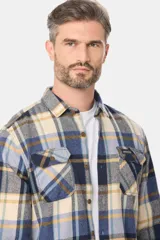 Sobrecamisa de estilo leñador con estampado de cuadros, confeccionada en tela de viyela. Presenta cuello clásico, cierre frontal con botones y dos bolsillos con solapa en el pecho.