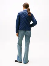 Campera Tommy Hilfiger azul marino con diseño acolchado a rombos, sin cuello y cierre a presión.