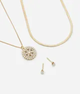 Conjunto de bisutería compuesto por un collar de doble cadena, una de ellas tipo serpiente y otra con dije circular pavé de zirconias, junto con un par de aros tipo punto de luz con zirconia. Acabado en baño de oro claro.