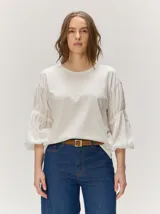 Remera color crudo de corte holgado, con cuerpo de algodón y mangas largas abullonadas semitransparentes con textura y diseño fruncido.