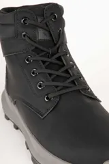 Borcegos deportivos de caña media, color negro, con cordones al tono y suela de plataforma gris con relieve antideslizante.