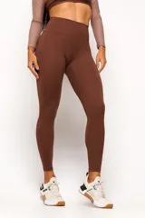 Calza deportiva marrón de tiro alto, confeccionada con tecnología de compresión y diseño ajustado.