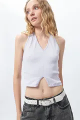 Crop top blanco de algodón, sin mangas, con cuello halter y abertura en el frente.