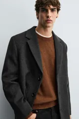 Abrigo regular fit de color negro, confeccionado con mezcla de lana y cashmere. Presenta cuello con solapas de muesca, manga larga, bolsillos de vivo en la cadera, abertura central en la espalda y cierre frontal de botonadura con tres botones.