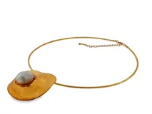 Collar tipo gargantilla de metal dorado con diseño escultural y orgánico, decorado con una perla en el centro.