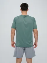 Remera deportiva Umbro modelo Axis, de manga corta, color gris claro con textura perforada transpirable y logo negro de la marca en el pecho.