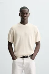 Camiseta negra de punto perlado, corte regular fit, cuello redondo, manga corta y rib en los acabados.