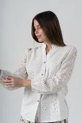 Camisa blanca de algodón con bordados perforados y botones de madera.