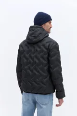 Campera de nylon matelaseada con capucha integrada, cierre frontal y diseño de costuras geométricas. Presenta un ajuste regular y es ideal para climas fríos.