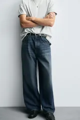 Jeans de denim de algodón, color azul oscuro con efecto lavado. Presentan un corte muy holgado (baggy fit) en toda la pierna y tiro medio. Tienen cinco bolsillos y cierre frontal con cremallera y botón.