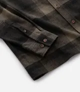 Camisa de manga larga con diseño de cuadros en tonos marrones, confeccionada en algodón. Presenta cuello camisero, cierre frontal con botones y un bolsillo en el pecho con botón.