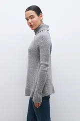 Sweater gris melange de tejido buclé con cuello alto y mangas largas.