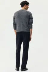 Pantalón sastrero de corte slim fit y color negro, con cierre frontal de botón, bolsillos laterales al bies y bolsillos posteriores ojalados. Cuenta con trabillas para cinturón y pretina elástica en la parte posterior.