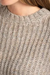 Sweater de punto grueso, color gris melange, con cuello redondo y manga larga, de calce oversize.