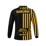 Camiseta de fútbol Puma del Club Atlético Peñarol, edición aniversario manga larga. Diseño con mitad derecha a rayas verticales amarillas y negras, y mitad izquierda negra con escudo retro "CUR" en dorado. Cuenta con cuello tipo polo negro con detalles amarillos y sponsors impresos en el frente y mangas.