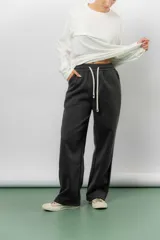 Pantalón deportivo de corte wide leg con caída relajada. Presenta cintura elastizada con cordón ajustable, bolsillos laterales y un interior frizado para mayor abrigo.