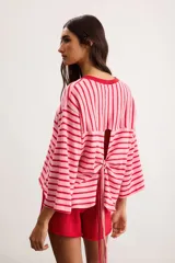 Remerón de algodón a rayas horizontales celestes y rojas, con silueta oversize, cuello redondo y mangas 3/4.