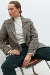 Blazer de paño con estampado a cuadros multicolor, solapas de muesca, cierre frontal con botones y mangas largas.