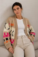 Cardigan de lana merino tejido a mano con diseño de motivos geométricos en contraste de colores beige, negro, fucsia y naranja. Presenta silueta relajada, mangas amplias y terminaciones de rib elástico.