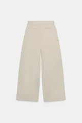 Pantalón de tiro medio con diseño de pierna ancha y pinzas frontales. Cuenta con bolsillos laterales ocultos, falsos bolsillos traseros de vivo, trabillas en la cintura y cierre frontal con cremallera y ganchos metálicos.