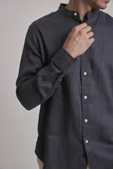 Camisa de lino color marrón, con cuello mao, manga larga y botones blancos.