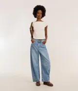 Pantalón de jeans celeste marmolado, corte barrel, con trabillas en la cintura, bolsillos delanteros y traseros, y detalle de recortes en las rodillas.