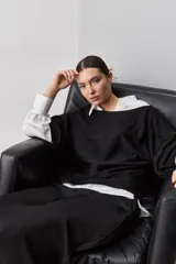 Sweater de punto liviano negro, con escote bote y mangas amplias de largo tres cuartos que aportan una silueta relajada y fluida.