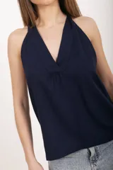 Top azul marino de lino y viscosa, con escote en V pronunciado, tirantes halter y corte fluido.
