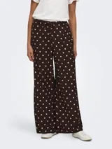 Pantalón suelto color marrón con estampado de lunares blancos, tiro medio y cintura elástica con cordón de ajuste.