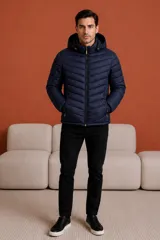 Campera puffer negra con capucha, cierre frontal completo y bolsillos laterales con cierre. Diseño acolchado con costuras horizontales.