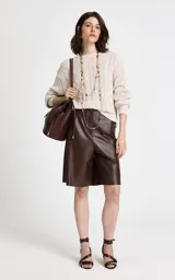 Sweater de punto beige con diseño de trenzas verticales, cuello redondo acanalado, mangas largas con puños ajustados y dobladillo acanalado.