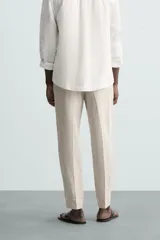 Pantalón de vestir azul marino confeccionado en tejido de lino. Corte recto, con bolsillos laterales y traseros. Se ajusta a la cintura con botón y cremallera.