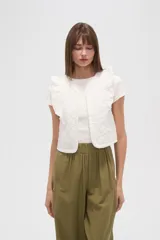 Chaleco corto de algodón con diseño capitoneado, cuello redondo y volados en los hombros.