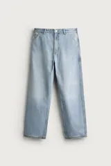 Pantalón jeans relaxed fit de color celeste claro con efecto lavado. Presenta diseño estilo carpintero con bolsillos frontales, tiras multifunción en la pernera, trabillas para cinto y cierre frontal con cremallera y botón metálico.
