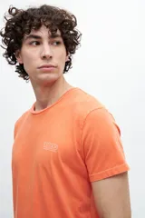 Remera naranja de algodón con estampa en la espalda que incluye texto y el logo de la marca.