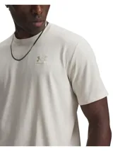 Remera Under Armour de manga corta color beige, con cuello redondo acanalado y logo bordado en el pecho.