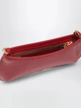 Cartera Le Petit Bisou Chaine de Jacquemus de cuero rojo, con silueta curva, correa de cadena dorada y logotipo metálico frontal.