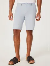 Bermuda de corte recto estilo chino, confeccionada en lino, con cierre de botón y cremallera, y bolsillos laterales.