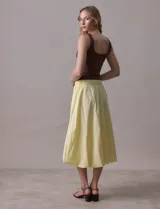 Falda midi color amarillo pálido, de algodón, con pretina ancha elastizada y forro interno a tono.