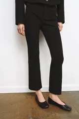 Pantalón cropped negro de tiro alto, con cintura con trabillas y falsos bolsillos delanteros. Cierre frontal con cremallera, botón y ganchos metálicos.