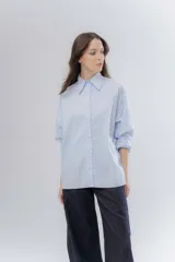 Camisa oversize celeste de algodón, con cuello camisero clásico y cierre frontal de botones.