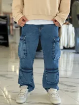 Pantalón de jean estilo cargo, color azul, de corte ancho y holgado, con múltiples bolsillos laterales en muslos y pantorrillas.