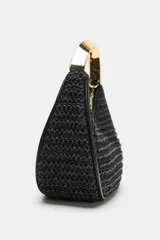 Bolso de mano mini en color negro con cuerpo trenzado y un asa rígida metálica dorada, además de una correa bandolera extraíble.