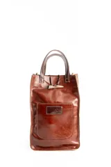 Bolso matero de cuero color marrón con manijas cortas, bolsillo frontal y cierre con tiento de madera.