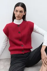 Chaleco tejido de punto acanalado en color rojo, con cuello redondo y cierre frontal de botones oscuros.