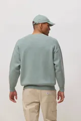 Sweater de punto de cuello redondo y manga larga, con diseño minimalista y logo pequeño bordado en el pecho.