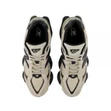 Championes New Balance modelo 9060, de diseño chunky en tonos beige y blanco con detalles en negro. Confeccionados en una combinación de malla y gamuza, cuentan con la icónica letra 'N' en los laterales y una suela robusta y esculpida.
