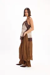 Pantalón negro de corte amplio, con cintura elástica fruncida y diseño abombacho con volados en los tobillos.