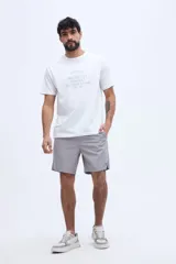 Remera blanca de manga corta con cuello redondo y estampa frontal de estilo vintage con texto inscripto.